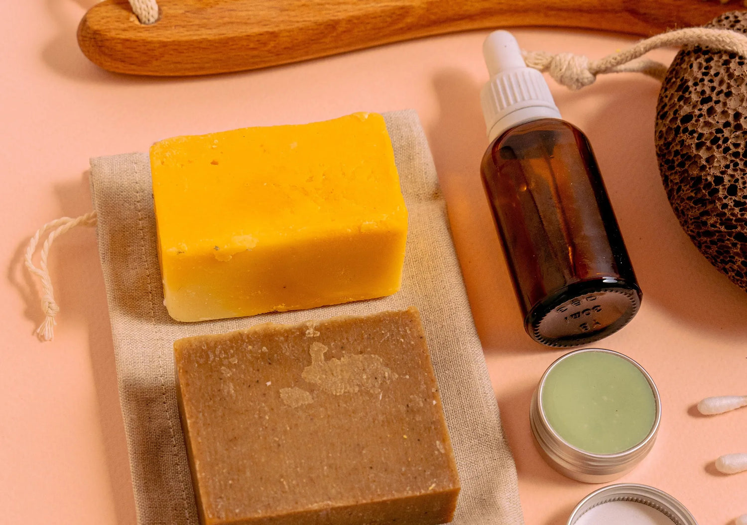 Selbst hergestellte Naturseifen neben braunem Glasfläschchen