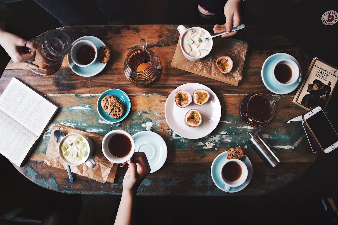 Gedeckter Frühstückstisch mit Kaffeetassen, Müsli und Früchten