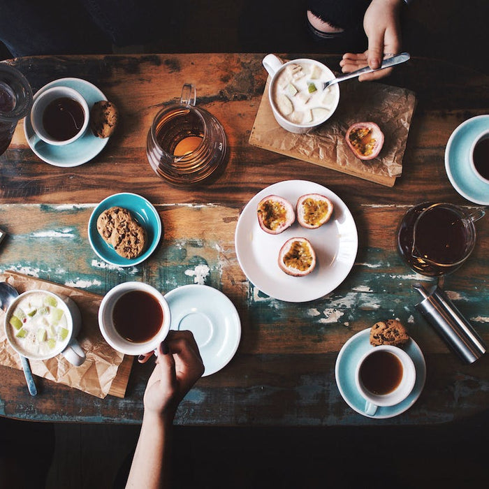 Gedeckter Frühstückstisch mit Kaffeetassen, Müsli und Früchten